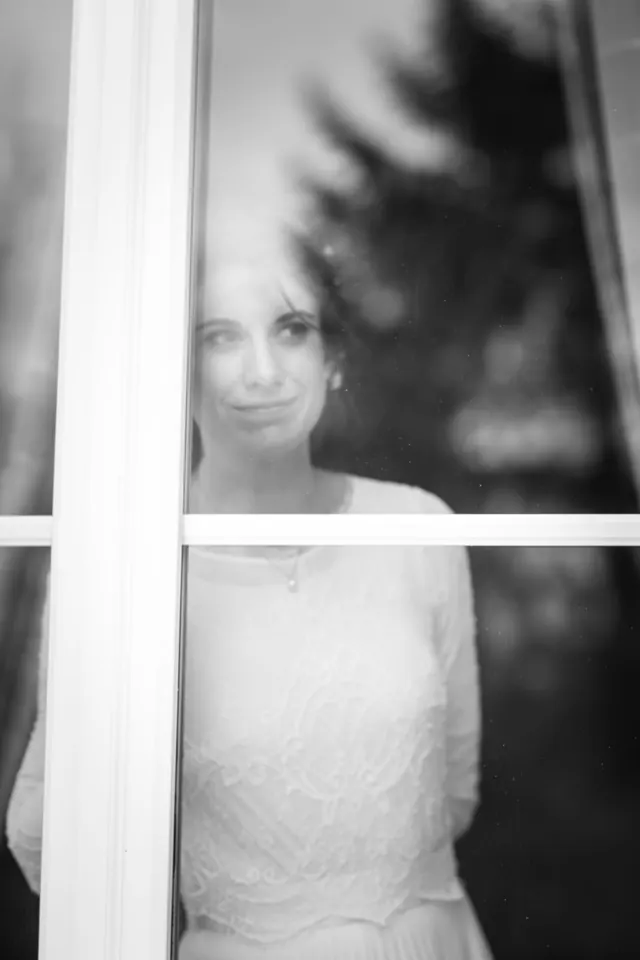 Mariée derrière une fenêtre pendant les préparatifs – photographe de mariage à Reims