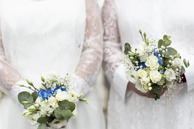 Deux bouquets de roses blanches et d'hortensias bleus sur des robes en dentelle – Frédéric Leroux, photographe de mariage à Reims