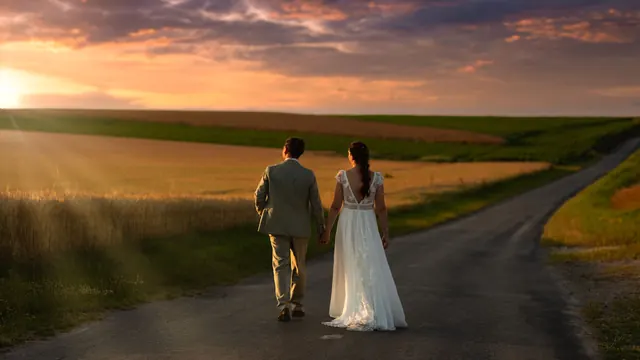 Mariés marchant sur une route entre les champs au coucher du soleil – Frédéric Leroux, photographe de mariage à Reims