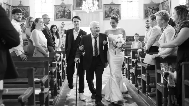Entrée de la mariée à l'église au bras de son grand-père, en noir et blanc – Frédéric Leroux, photographe de mariage à Reims